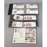 Two albums of First Day covers along with album of unfranked, mostly commemorative, British stamps .