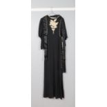 A John Bates for Jean Varon vintage black dress featuring full length dolman sleeves and gold