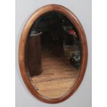 An Edwardian inlaid oval bevel edge wall mirror. (82cm x 56cm) Slight foxing to the glass.