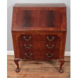 A carved mahogany bureau raised on ball and claw feet with leather inset interior. (102cm x 75cm)