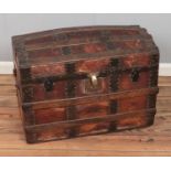 A wood-bound leather dome-top steamer trunk with geometric motifs. Hx55cm Wx72cm Dx43cm