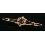 An Edwardian 15ct gold bow brooch set with central amethyst and seed pearl. Pin stamped 9ct. Total