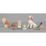 A collection of ceramic birds, together with a Labrador Retriever puppy. Birds include Beswick