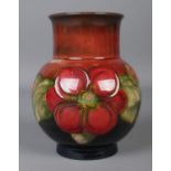 A Moorcroft pottery mottled dark blue and red ground vase in the 'Clematis' design. Impressed