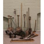 A collection of garden tools including shears, forks and hoes, together with a push-along Webb