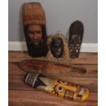A box of tribal masks and decorative paddle.