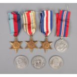 A group of four World War Two medals along with three commemorative coins. Medals include War medal,