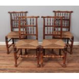 A set of four spindle back chairs with rush seats. One missing a single spindle to back.