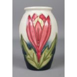 A Moorcroft pottery dark blue and cream vase in the 'Crocus' design, with three budding flowers.