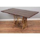 A garden table with cast iron Singer sewing machine treadle base. (75cm x 145cm x 74cm)