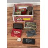 A box of assorted vintage tins along with two boxes of glass slides depicting industrial equipment.