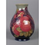 A Moorcroft pottery green to dark blue ground vase, in the 'Finches and Fruit' design, . Bearing '