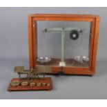 A cased set of chemical scales along with vintage brass postal scales with weights.