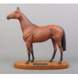 A connoisseur model by Beswick of Red Rum, raised on wooden plinth. Height: 32cm.