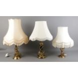 Three brass bodied table lamps, all with frilled cream shades.