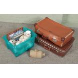 A box of assorted ceramics along with two suitcases. Includes Carol Craft figures, Norville,