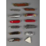 A collection of folding pen knives to include Swiss Victorinox and Wenger examples.