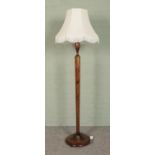 An oak standard lamp, with hexagonal column, baluster top and turned base. With cream frilled shade.