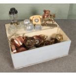 An ottoman full of mixed metal and glassware items including Tilley lamp, copper and glass jelly