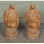 A pair of painted reconstituted stone eagles.