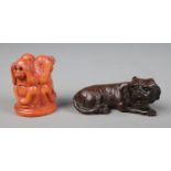 Two hand carved hardwood netsuke one of a tiger and another of the three wise monkeys.
