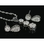 A 14ct white gold and diamond cluster jewellery suite, consisting of drop pendant on chain and