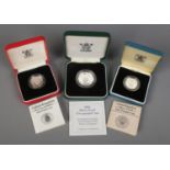 Three cased Royal Mint silver coins. Includes two one pound coins and a 1994 two pound coin.