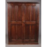An early twentieth century ecclesiastical style oak cabinet with paneled front doors and later