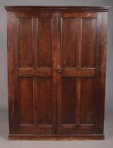 An early twentieth century ecclesiastical style oak cabinet with paneled front doors and later