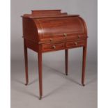 An Edwardian mahogany cylinder desk, having fitted interior, tapering supports and strung inlay.