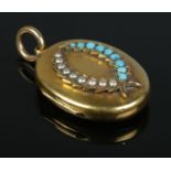 A Victorian gold locket with seed pearl and turquoise set laurel decoration. 11.04g. Tests as