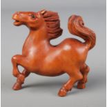 A hand carved hardwood netsuke of a stallion / horse with signature to base.