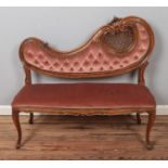 A French style two seat parlour sofa with ornate carved wood decoration.