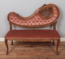 A French style two seat parlour sofa with ornate carved wood decoration.