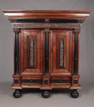 A rosewood and ebonised Schrank with applied carved decoration in the Baroque style. Having two