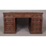 A Victorian carved oak twin pedestal desk. Height 77cm, Width 140cm, Depth 77cm.