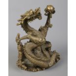 A cast bronze sculpture of a Chinese dragon holding a flaming pearl. Height 18cm.