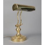 A vintage brass articulated desk light with cylindrical curved shade. In working order.