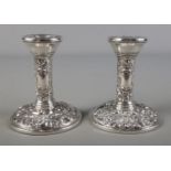 A pair of silver filled candlesticks each with repousse bird and foliate decoration, Birmingham 1968