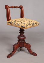 A Victorian carved mahogany piano stool. Having upholstered seat and turned back rest. Height 68.