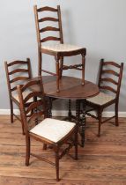 An oak drop leaf dining table with barley twist gateleg support along with four ladder back dining