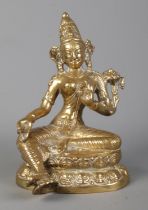 A Sino Tibetan cast gilt metal figure of a seated deity. Height 17.5cm.