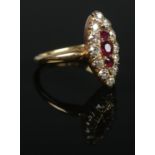 An 18ct gold diamond and ruby navette ring. The three graduating ruby stones within a border of