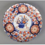 An Oriental Imari dish. (30cm diameter) Chip to rim.