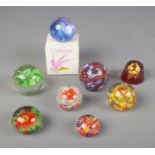 A collection of glass paper weights with one resin example and one boxed Caithness paperweight