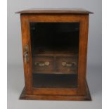 A small oak smokers cabinet with glass door front, pipe racks and two drawers. Approx. dimensions