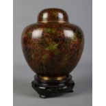 A lidded Cloisonne jar on stand decorated with floral motifs. Approx. height on stand 20cm.