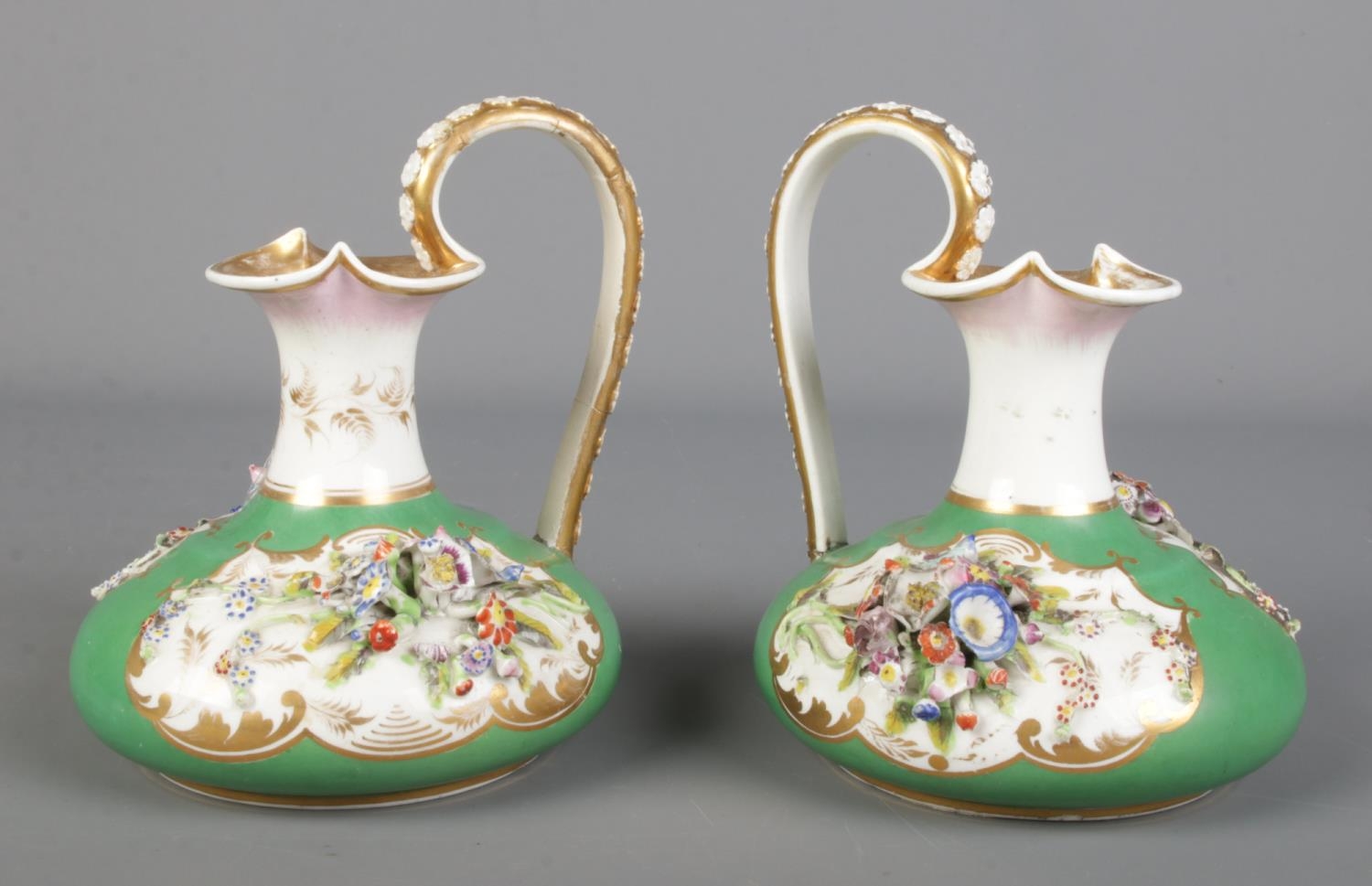 A pair of 19th century Derby Bloor ewers, green ground with applied flowers and gilt decoration.