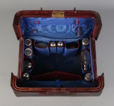A late 19th/early 20th century leather dressing bag, with blue silk lining and fitted compartments