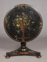 A 19th century lacquered tilt top table with painted floral and gilt decoration. Diameter of top